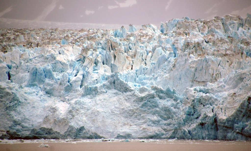 The blue-white face of a tidewater glacier meeting the sea